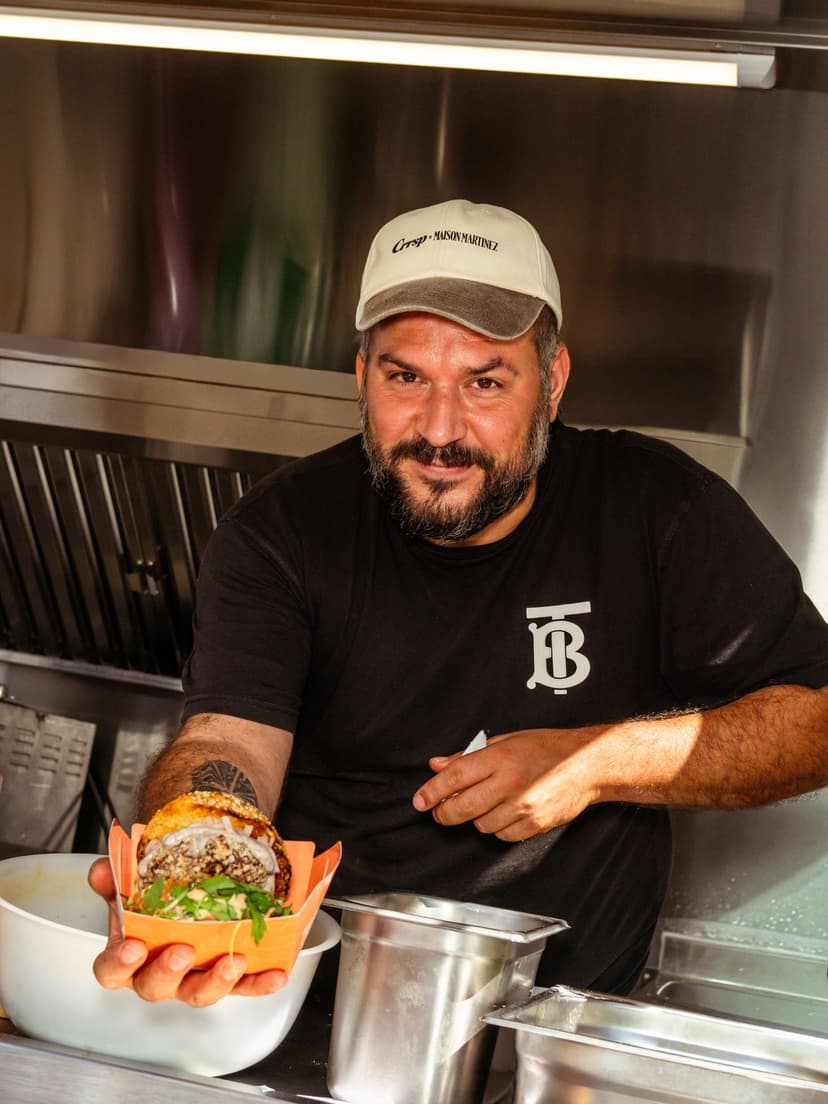 Chef de food truck présentant un plat dans sa remorque